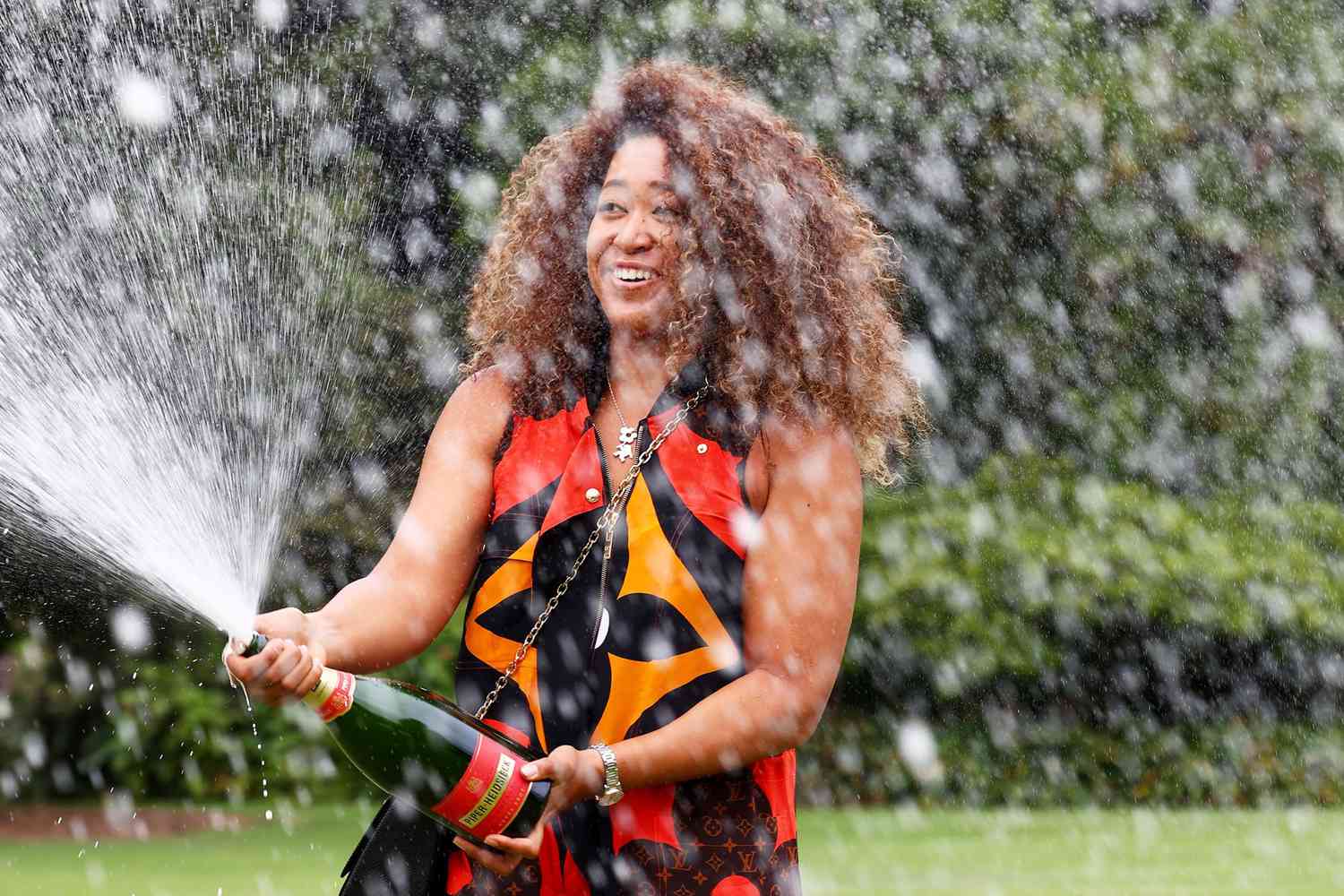 Naomi Osaka of Japan sprays champagne during a photo shoot of the 2021 Australian Open winner's trophy at the Government House in Melbourne on February 21, 2021