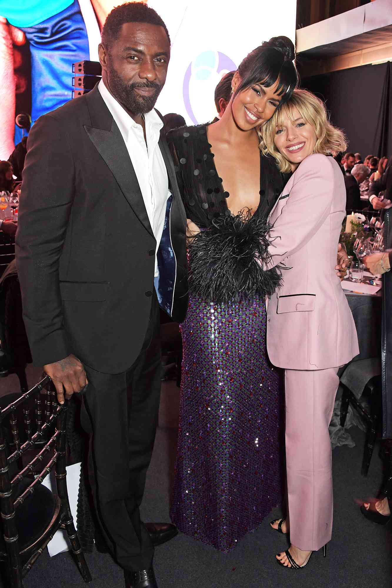 LONDON, ENGLAND - DECEMBER 01: (L to R) Idris Elba, Sabrina Dhowre Elba and Sienna Miller attend the mothers2mothers 20th Anniversary Gala at Outernet London on December 1, 2021 in London, England. (Photo by David M. Benett/Dave Benett/Getty Images for Gucci)