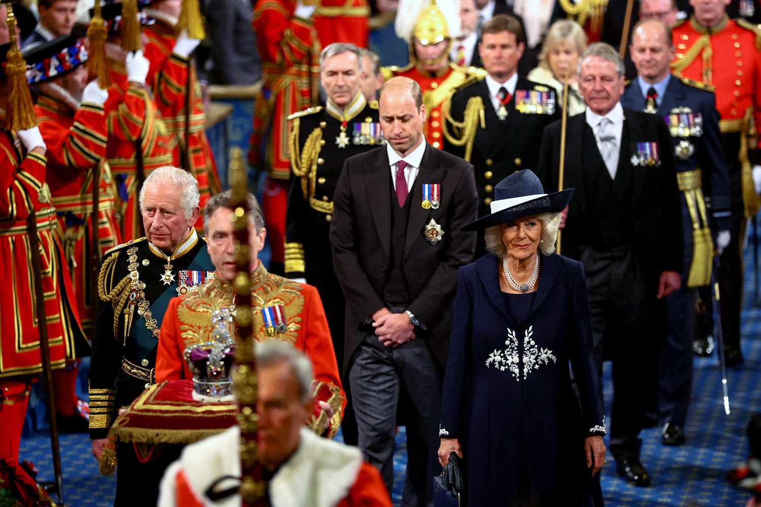 Prince Charles, Prince of Wales (L), the Imperial State Crown (C), Britain's Camilla, Duchess of Cornwall (R) and Britain's Prince William, Duke of Cambridge (rear C) proccess through the Royal Gallery during the State Opening of Parliament