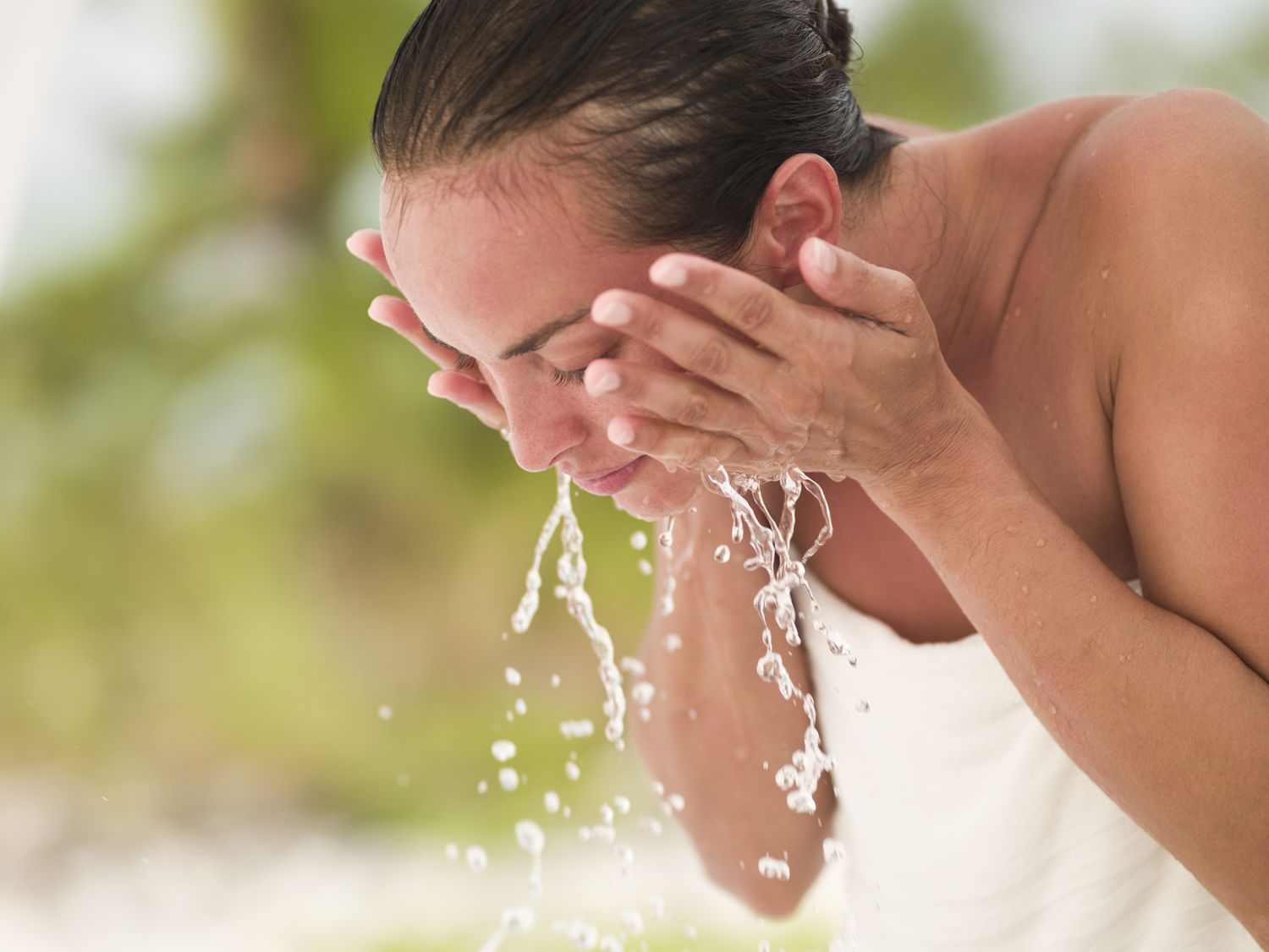 Woman washing her face in water