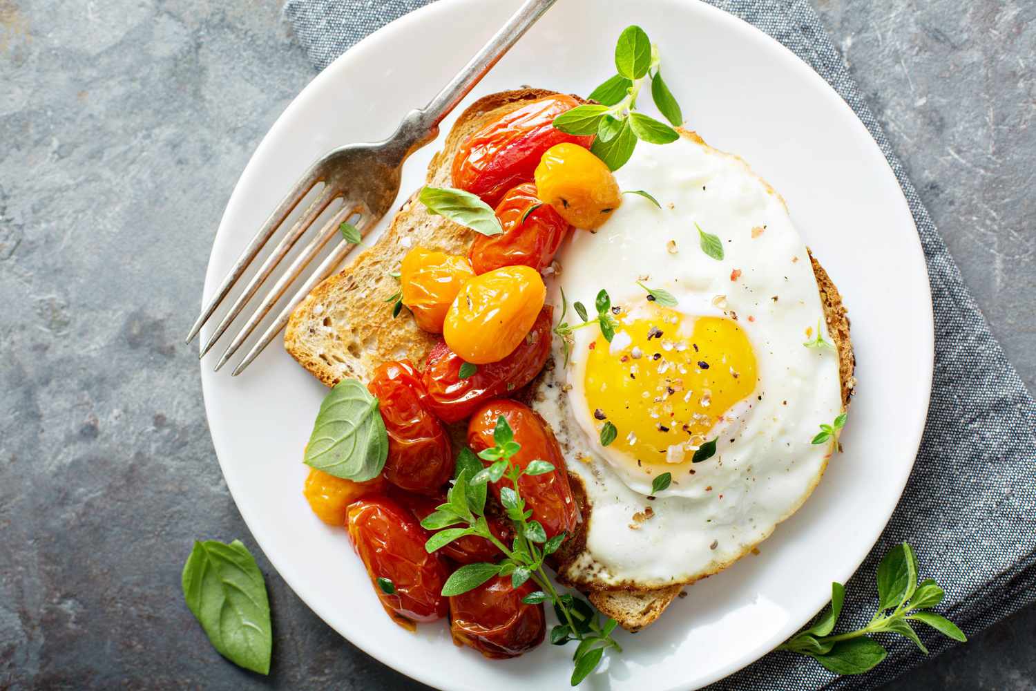 Multigrain toast with fried egg and roasted tomatoes