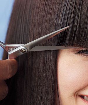 Woman cutting bangs