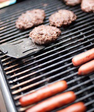 Cooking hamburgers and hot dogs on barbecue