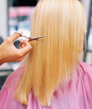 Blonde woman getting her hair cut at a salon