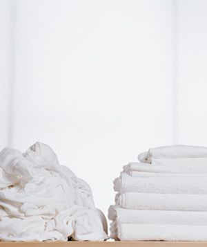Stacks of unfolded and folded white laundry