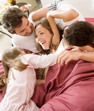 Family in pajamas on a bed