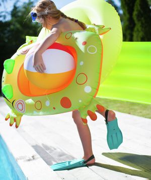 Girl carrying flotation toys for pool