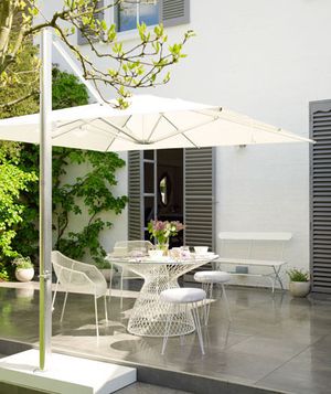 White table, chairs, and parasol on outdoor patio