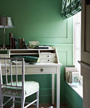 Room with green walls and white desk
