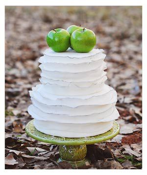 White wedding cake with green apples on top