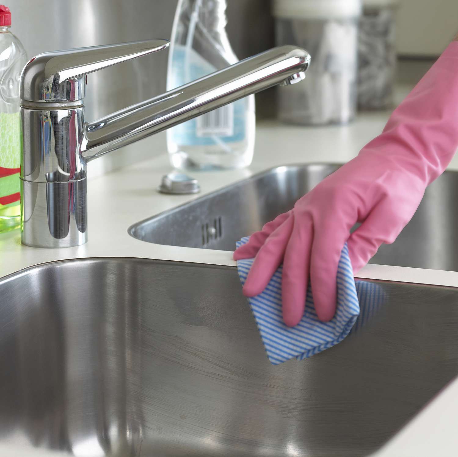 Cleaning kitchen sink with rubber gloves