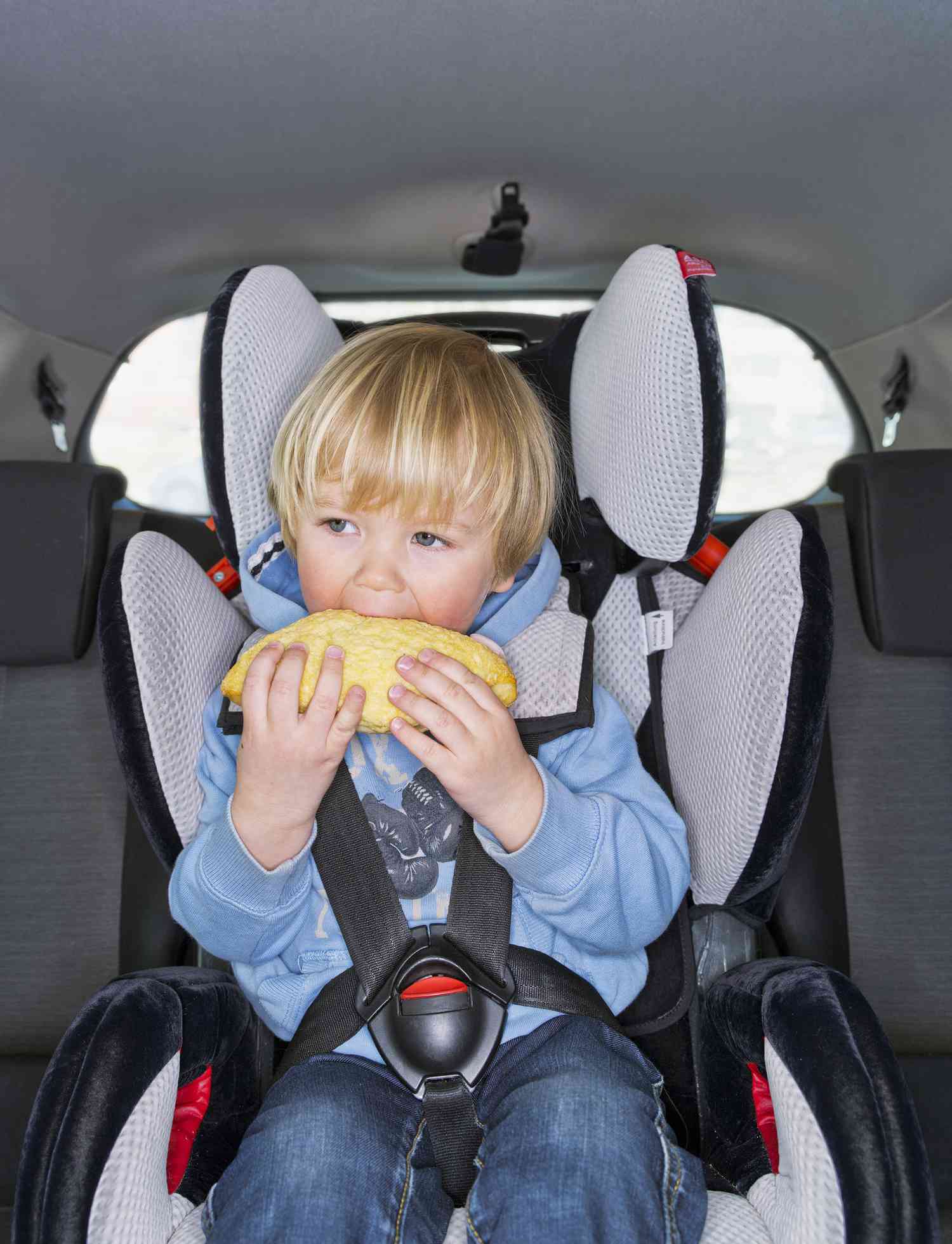 Road trip snacks, kid eating in car