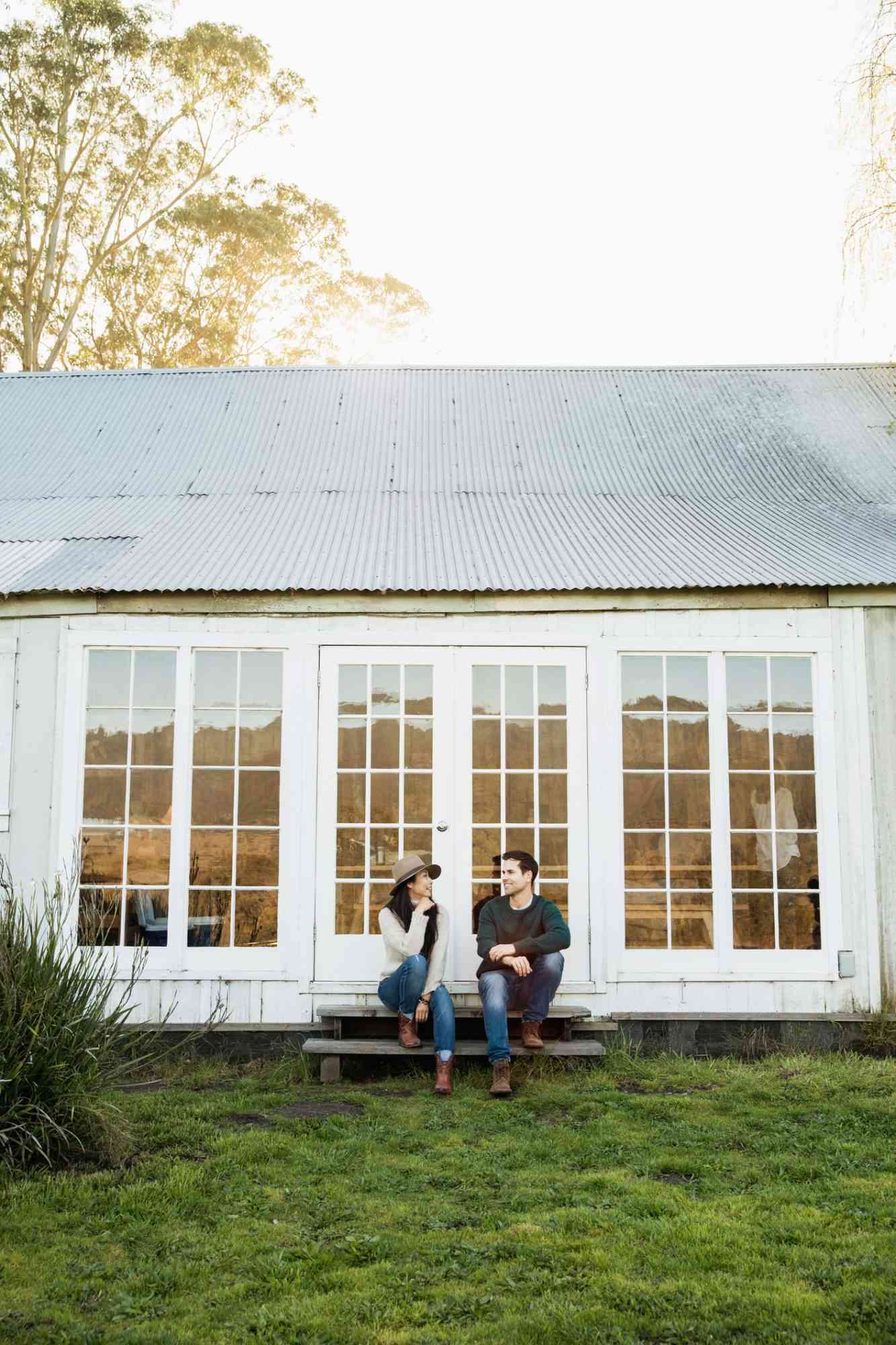 Couple sitting on the porch of their country house
