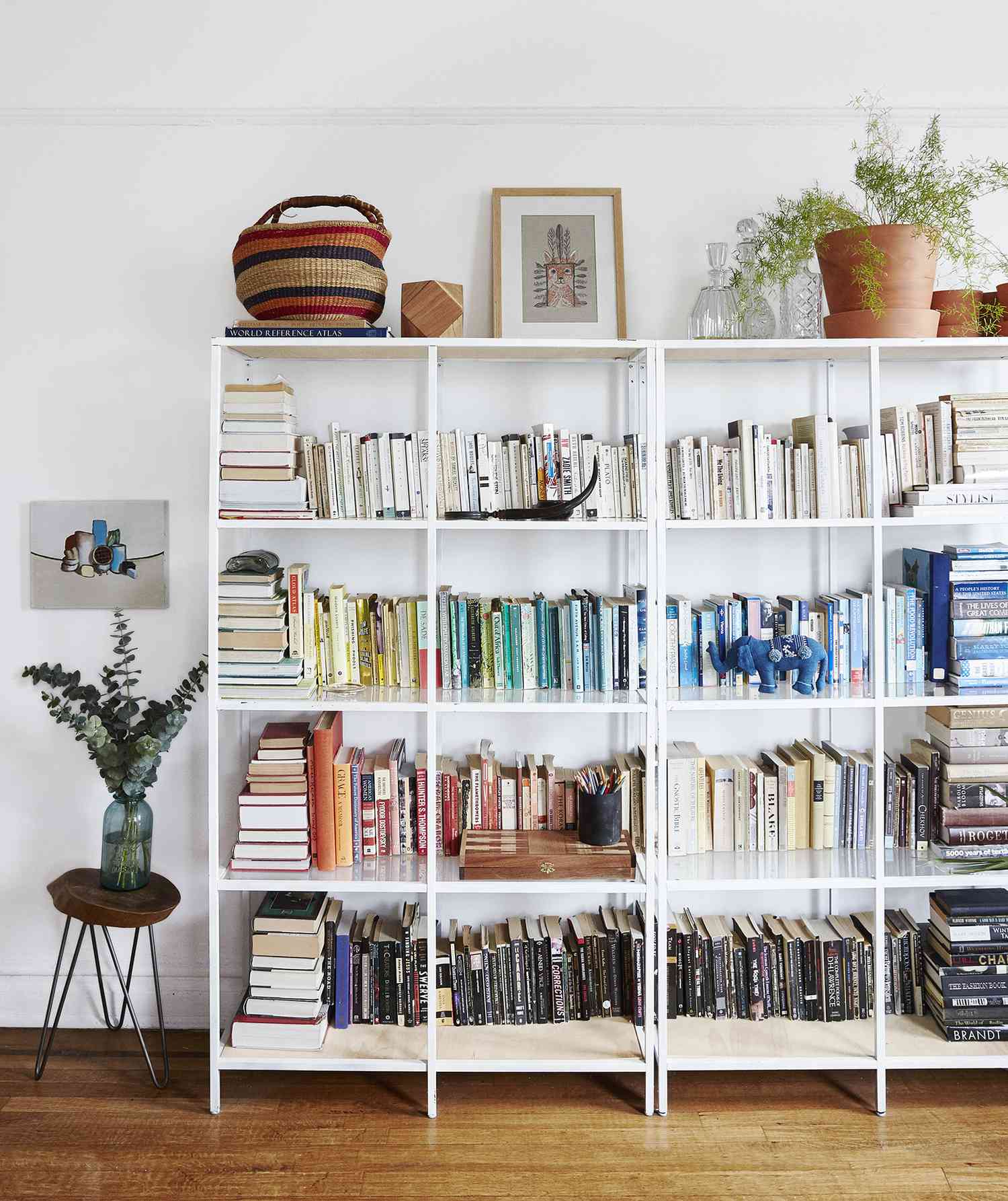 White bookshelves arranged by color