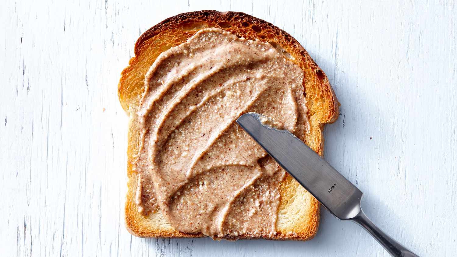 Best Nut Butters: knife spreading nut butter on bread