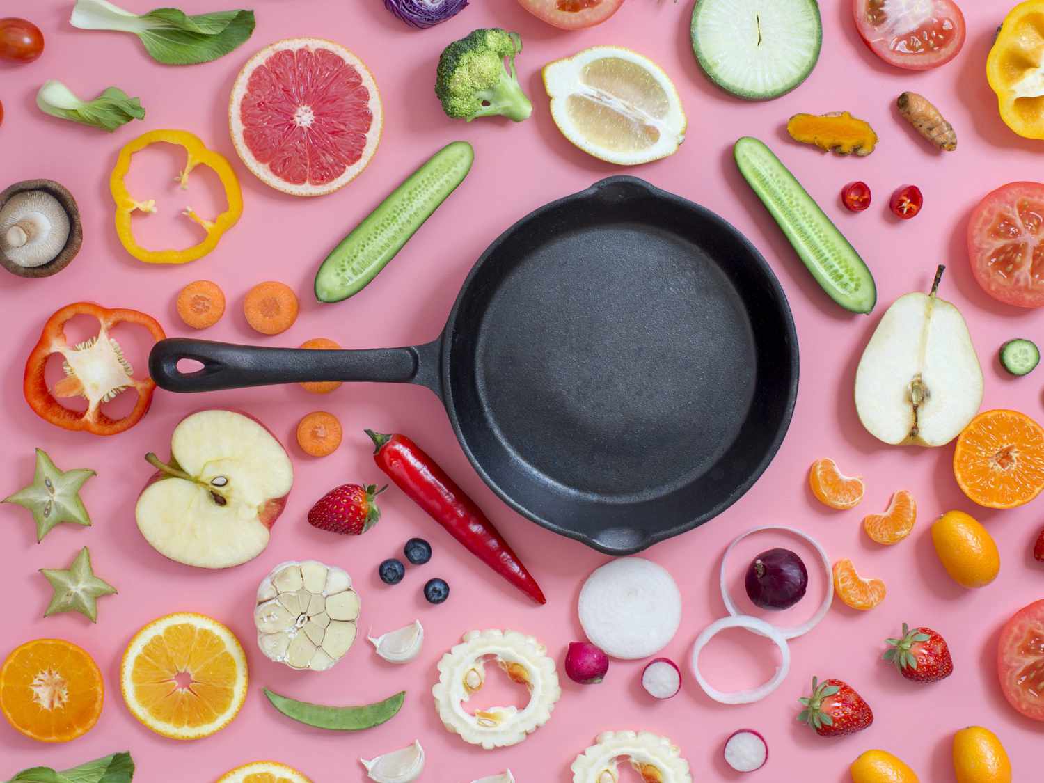 biggest-cooking-mistakes: cast iron pan surrounded by a variety of ingredients