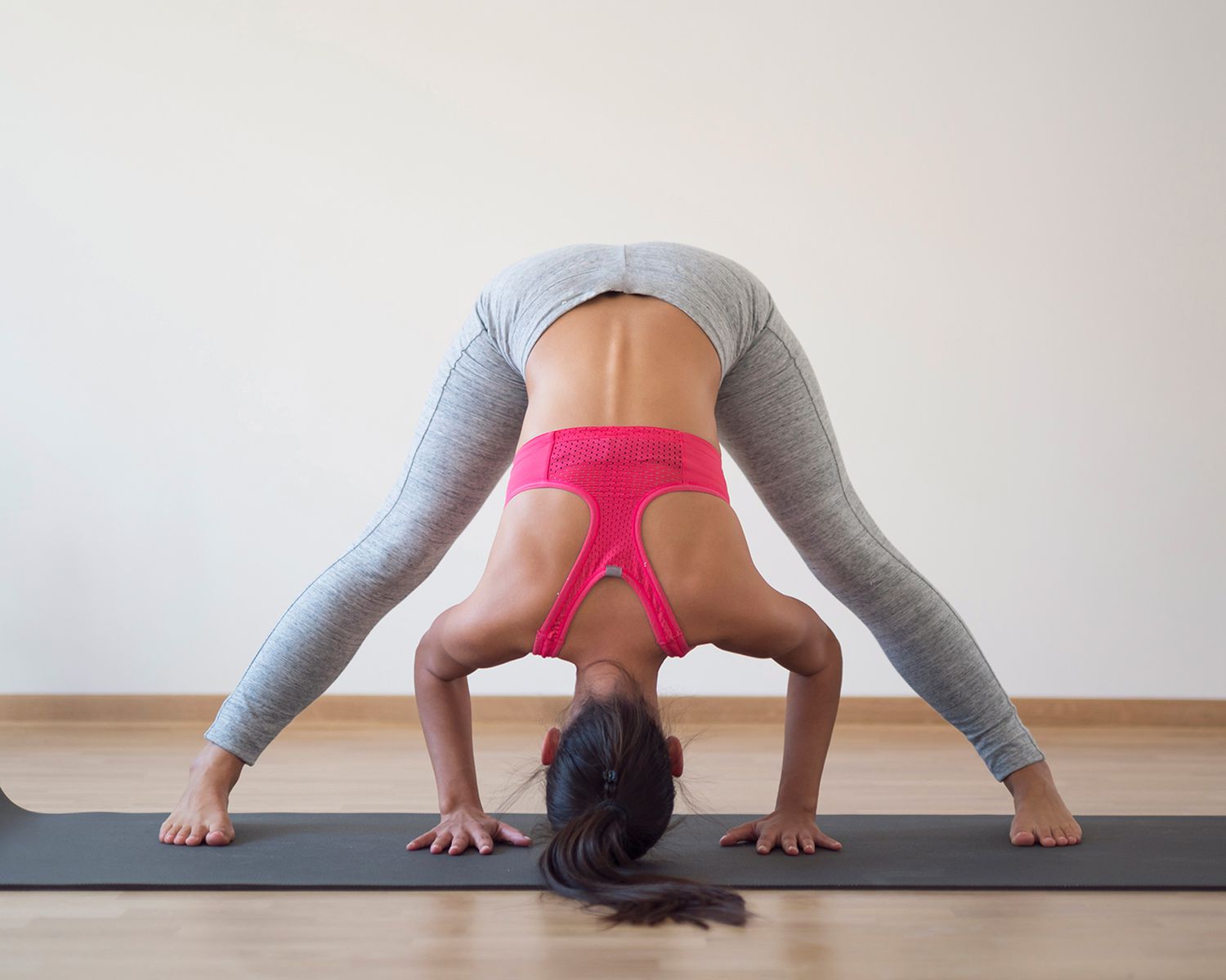 Restorative Yoga: woman doing wide-angle forward fold yoga pose