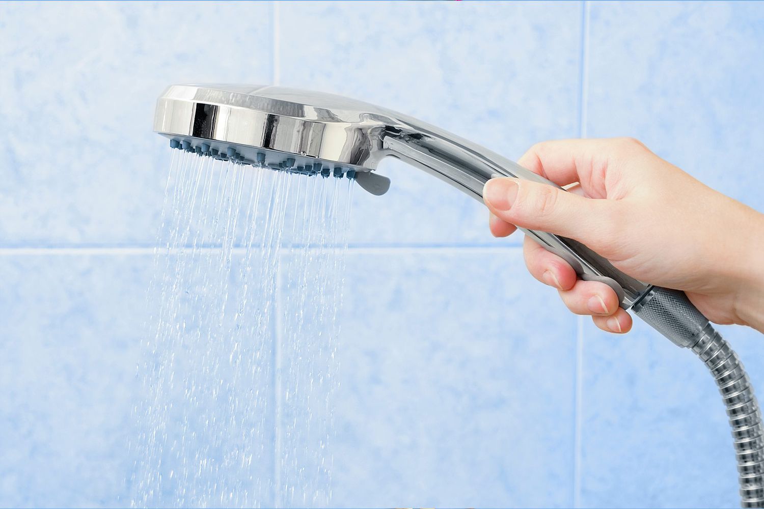 Health Benefits of Taking Cold Showers: close-up of hand holding shower head