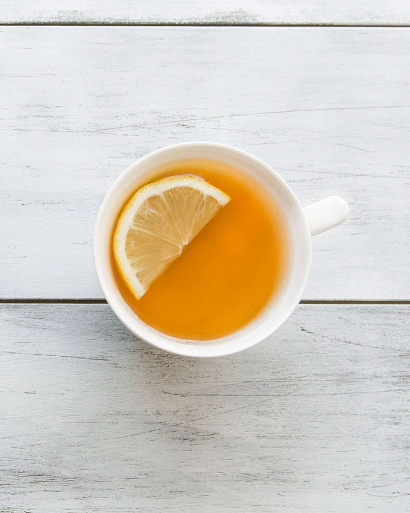 cup of ginger tea with a wedge of lemon