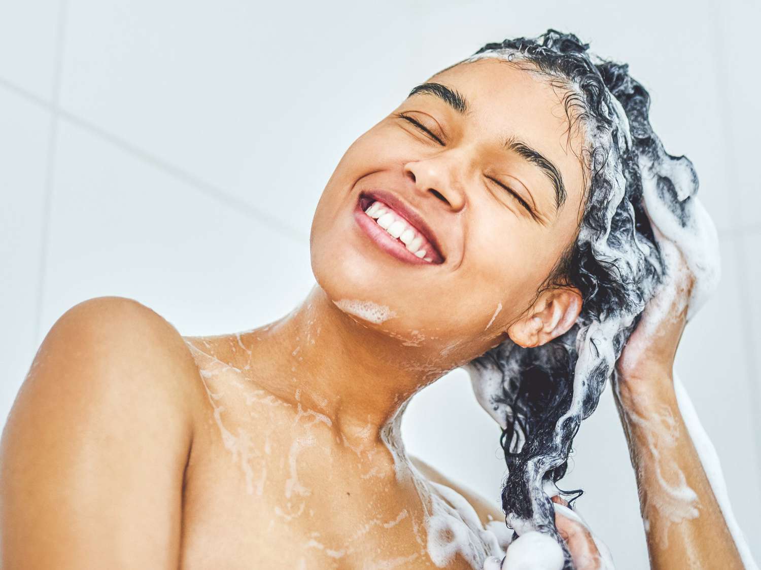 woman washing hair: olaplex