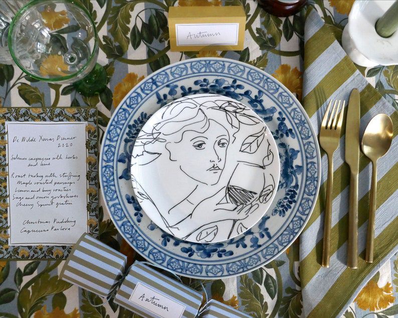 table set with gold stripe tablecloth and blue plates