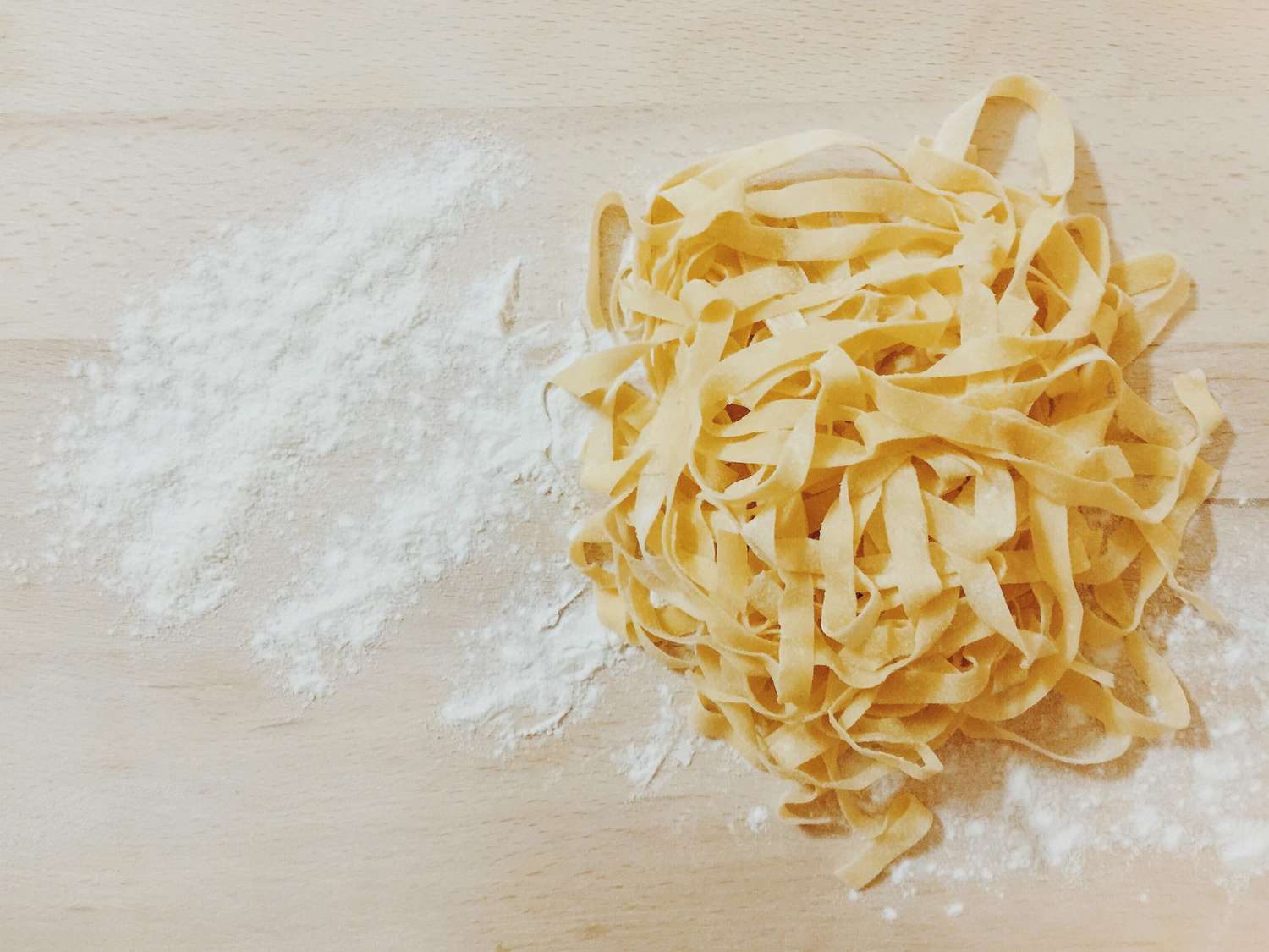 High Angle View Of Pasta And Flour On Wooden Table