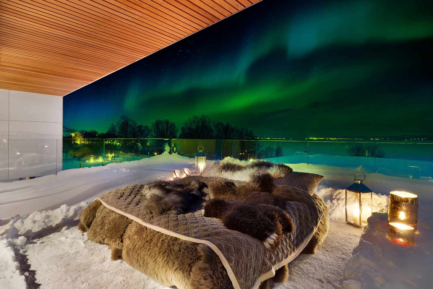 outdoor bed with northern lights in background