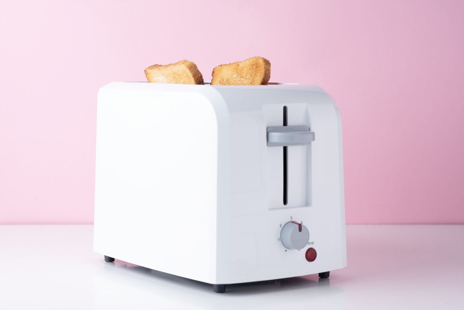 toaster with bread in it on a pink background