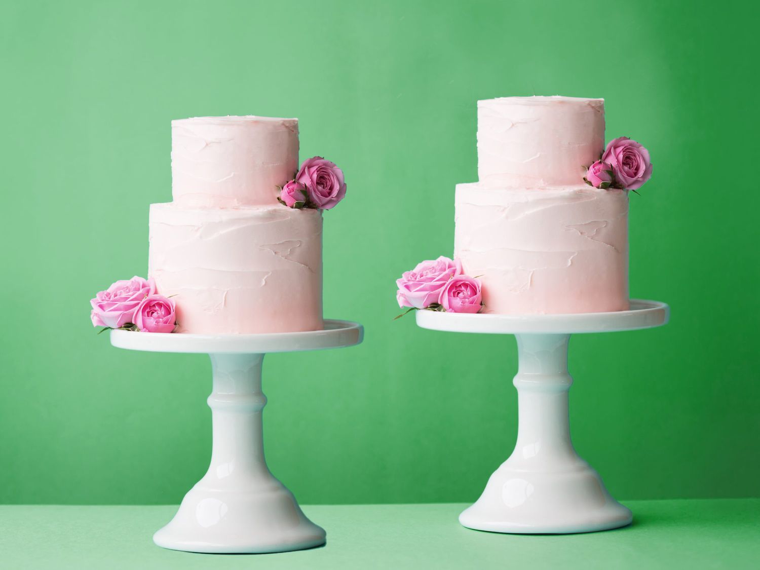 two wedding cakes on a green background