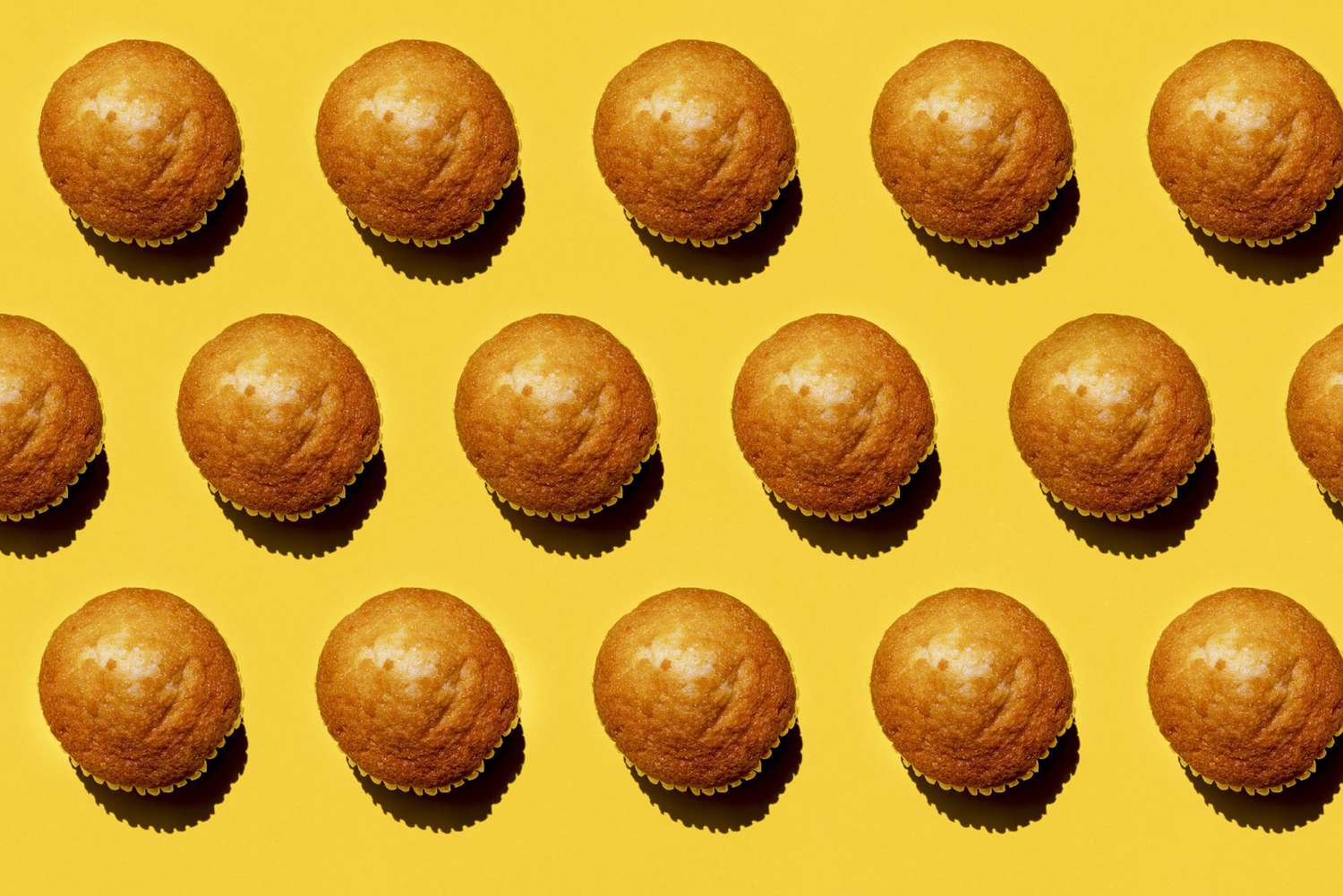 Pattern of rows of muffins against yellow background