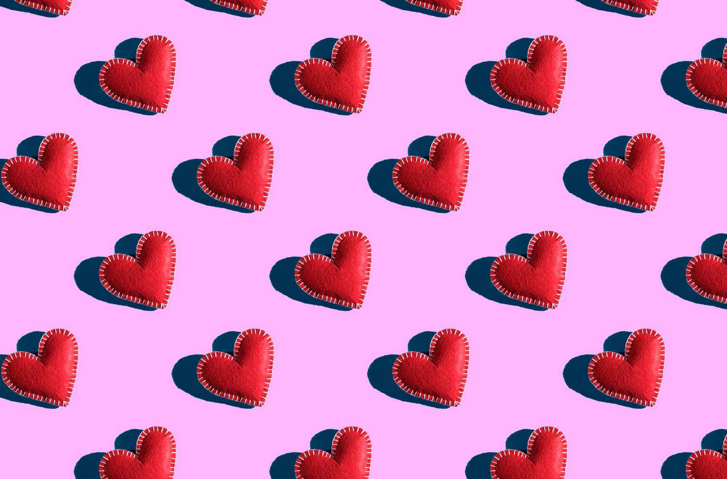 Seamless pattern of Red Hearts on a Pink Background. The background of Valentine's day. Handmade work.