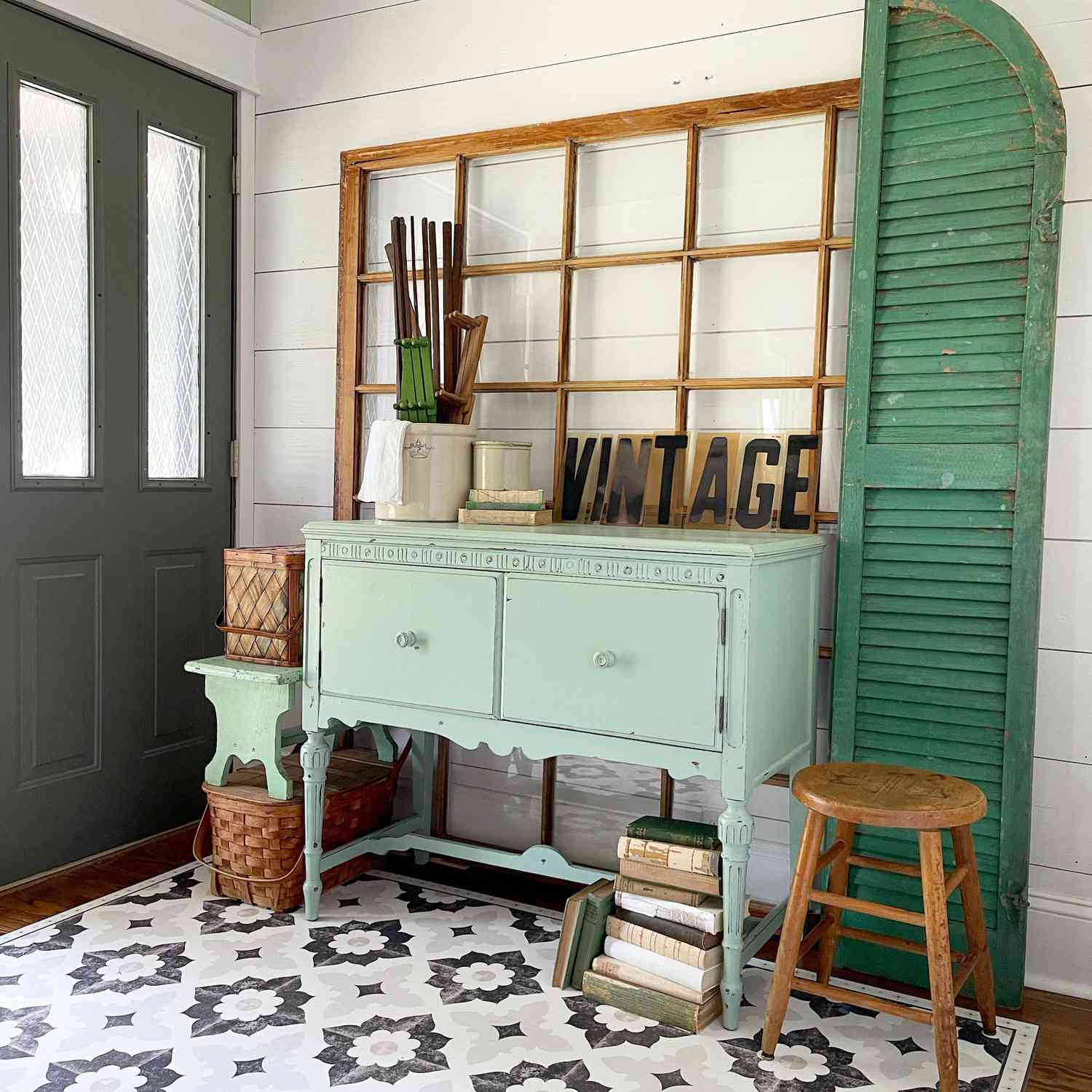 Entryway with vintage green decor and storage cabinet, window panes, shutters
