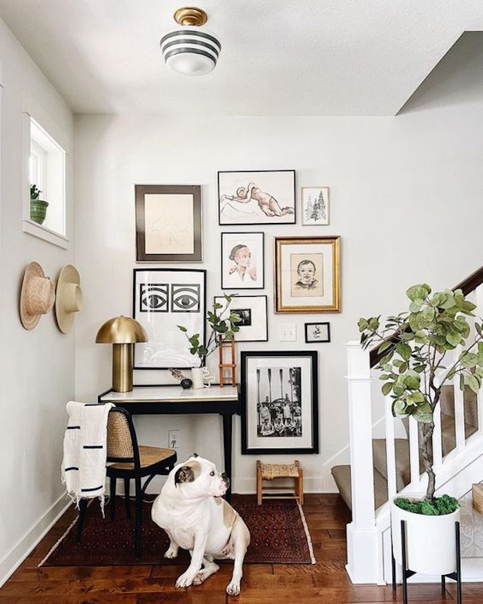 entryway with neutral color gallery wall and small desk