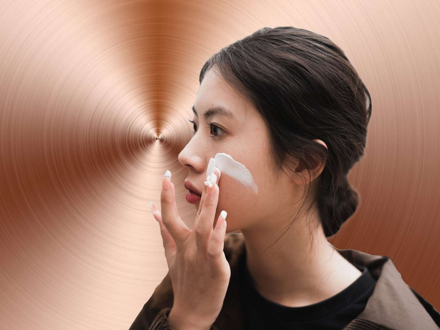 An Asian girl is using cosmetics in front of a mirror