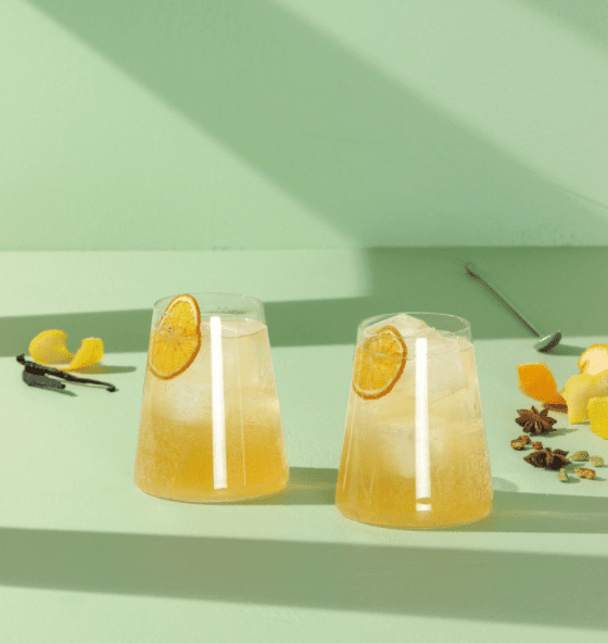 Two glasses of citrus cocktail with a orange slice garnish