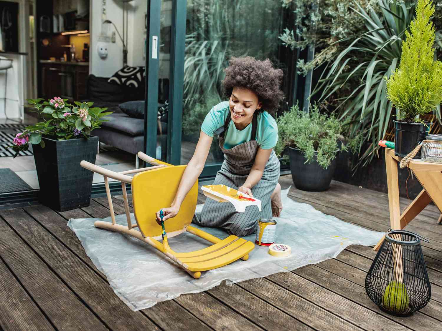 Woman is painting a chair at home