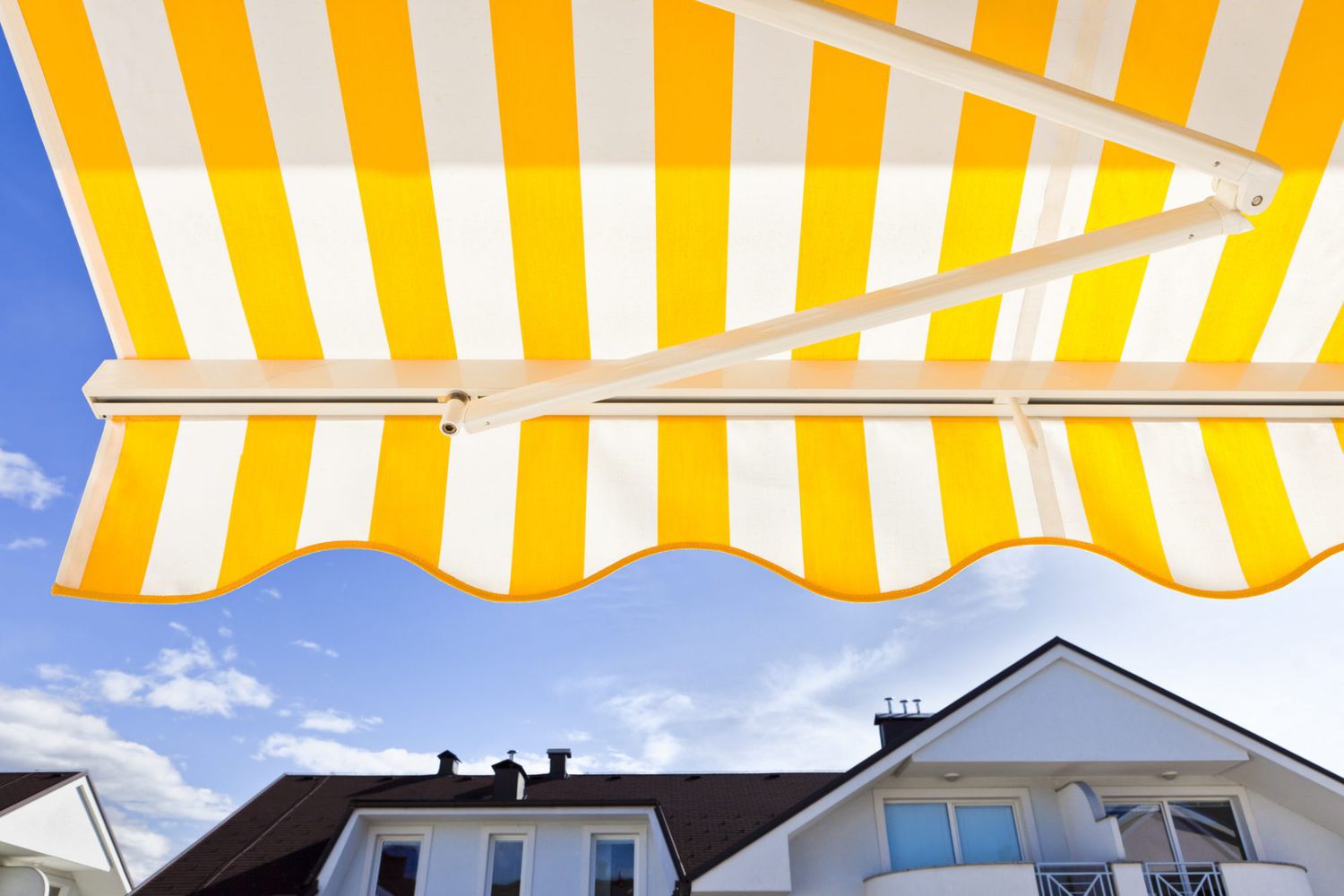 Yellow striped awning against a blue sky
