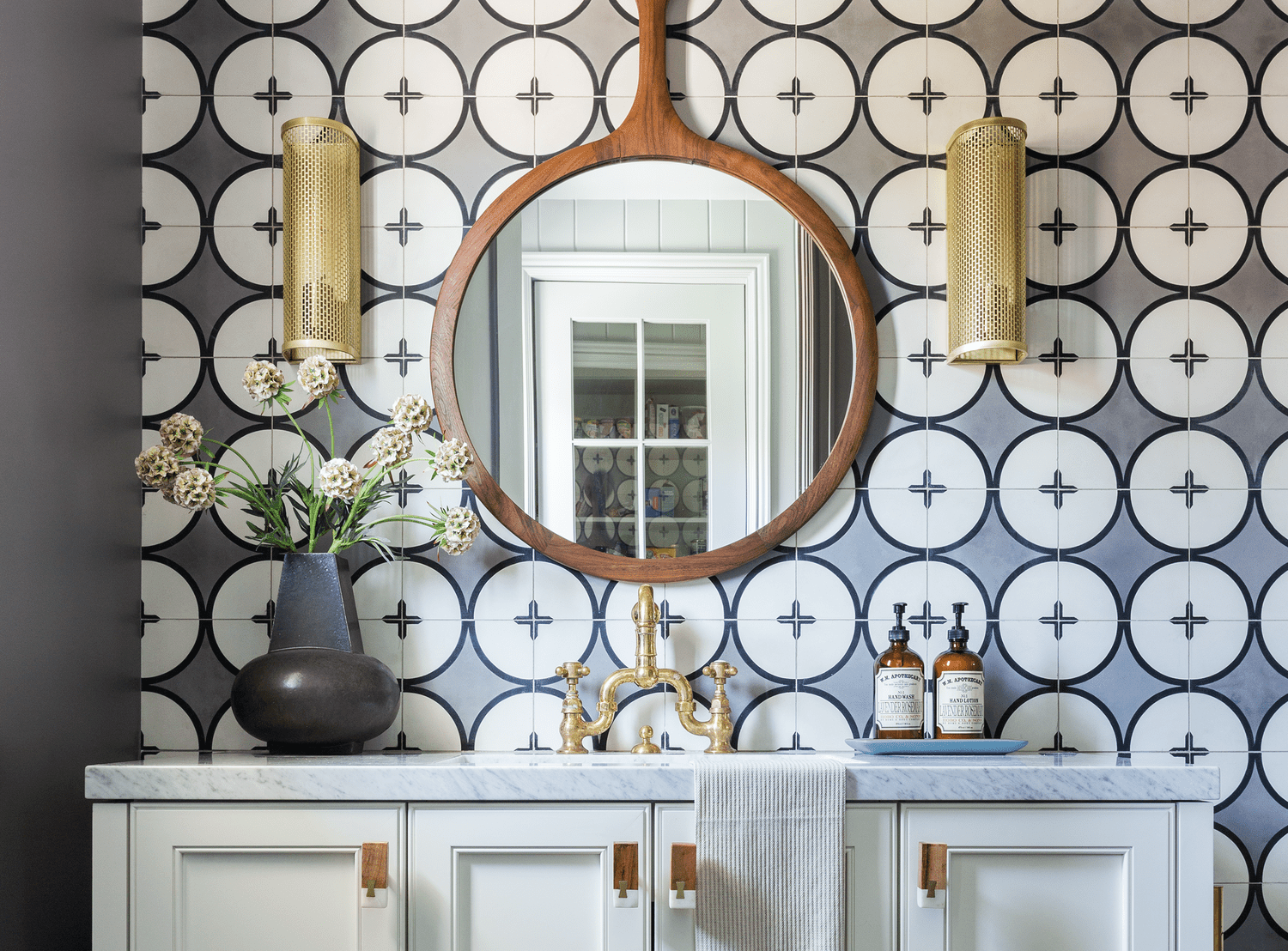 circular gray patterned tiles on focal wall in bathroom with white vanity
