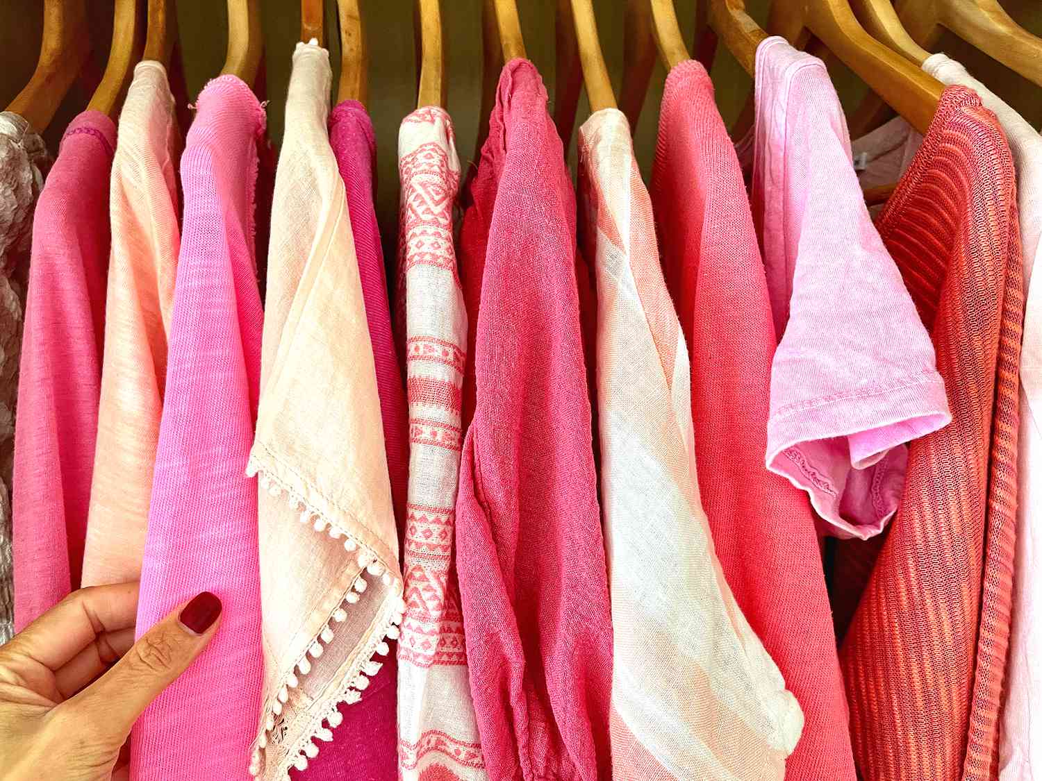 pink clothes hanging on wooden hangers