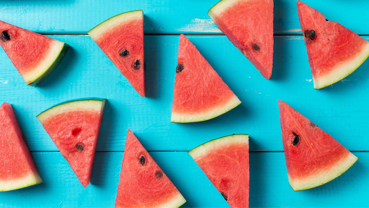 slices of watermelon on a teal wood surface