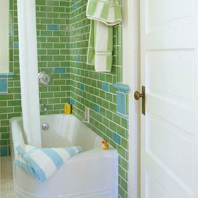colorful green tiles (interspersed with light blue tiles) line the walls of a retro styled bathroom
