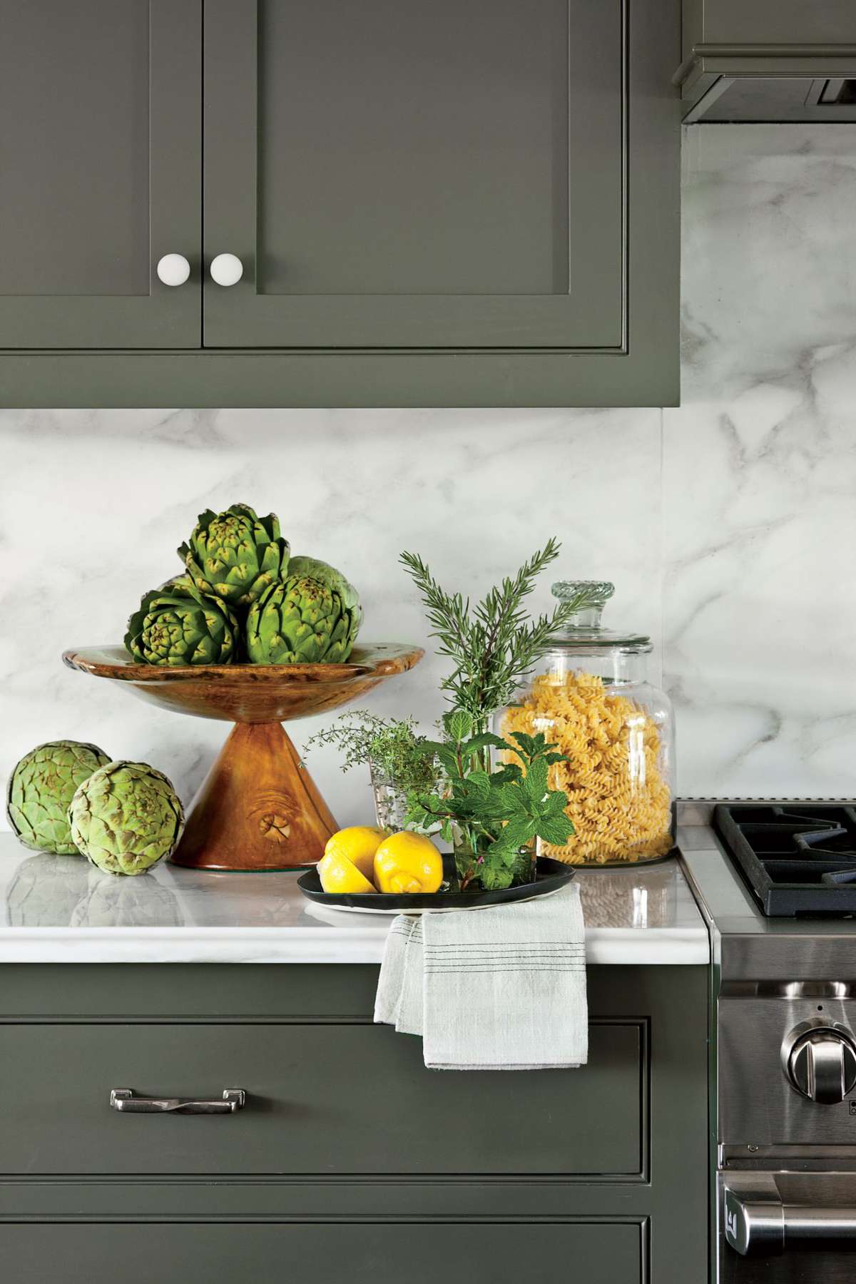 Dark Green kitchen cabinets with marble slab backsplash