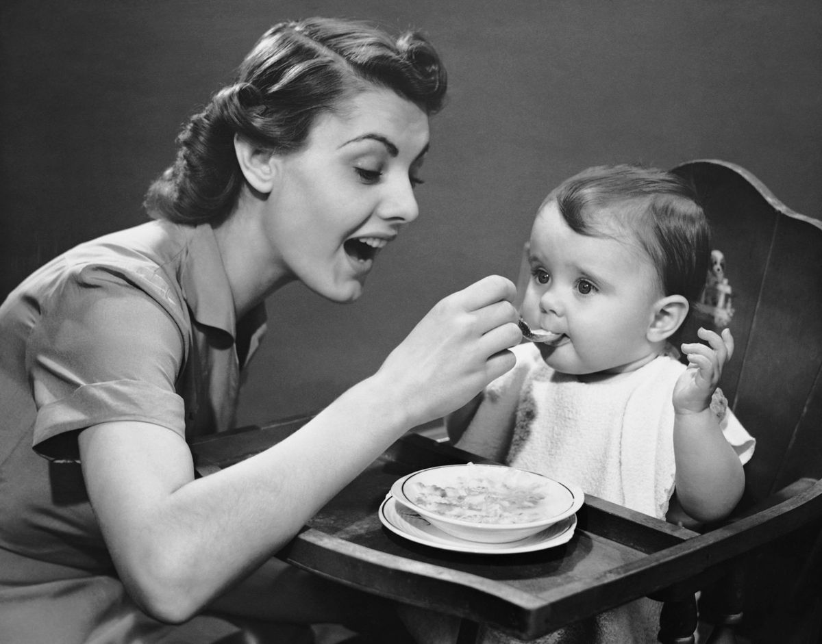Mother feeding baby vintage photo
