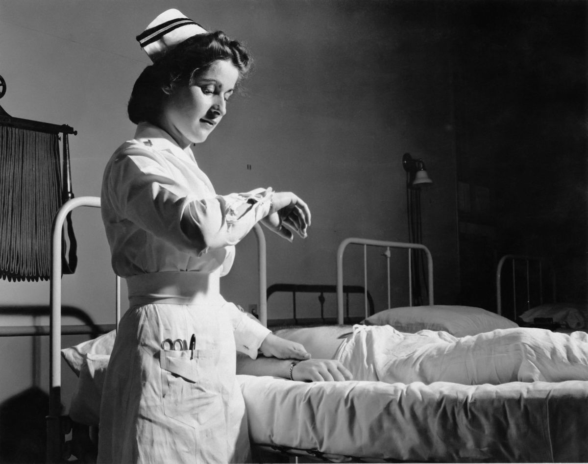 1950s nurse taking pulse of patient