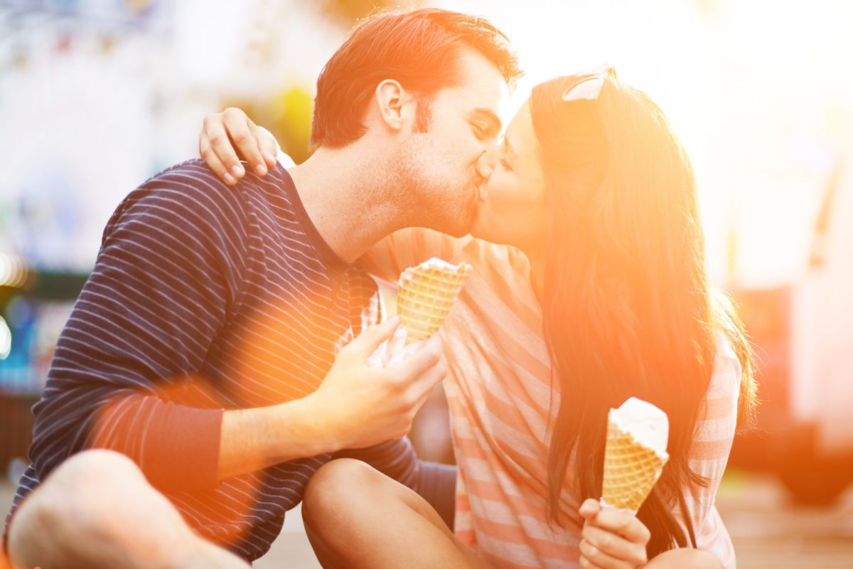 Couple Kissing while Holding Ice Cream