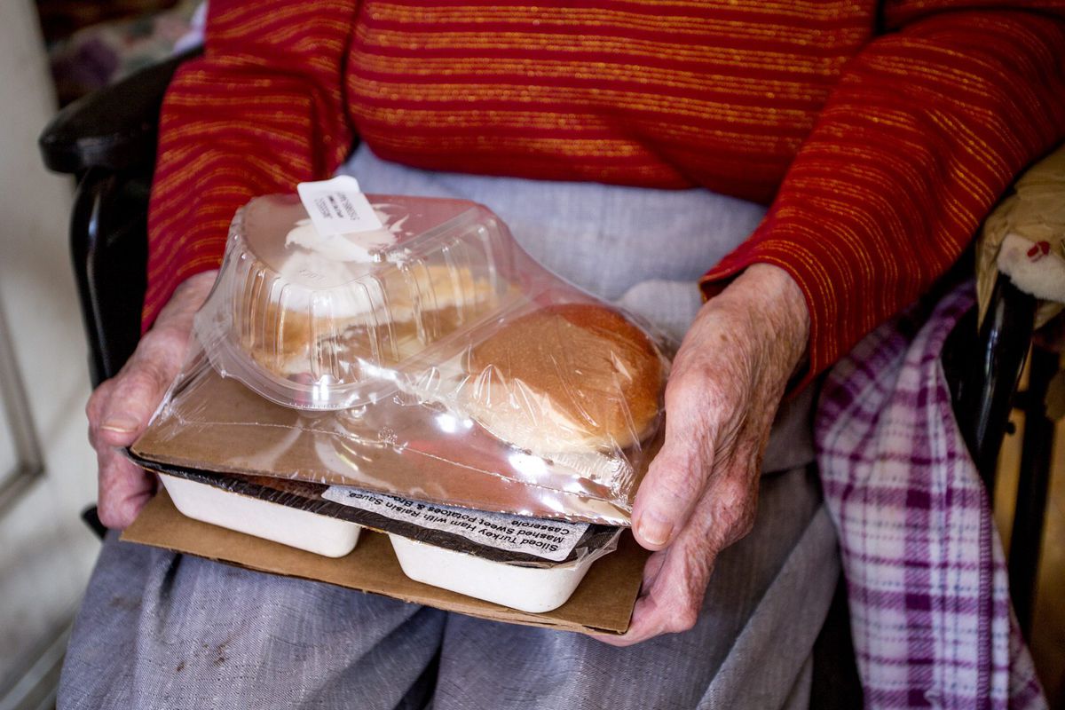 Close Up Elderly Hands Holding Packaged Meal