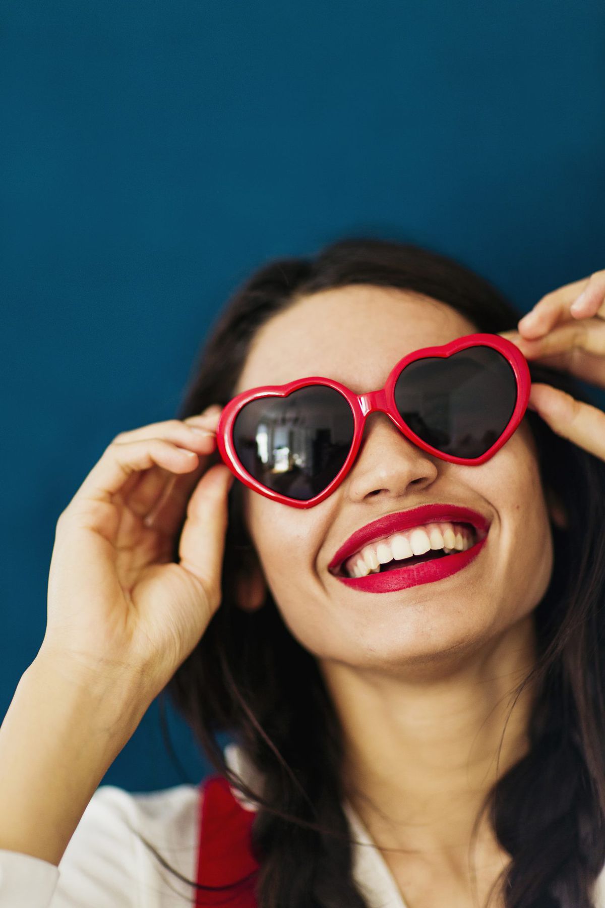 Woman with Red Lipstick and Heart Shaped Sunglasses Smiling