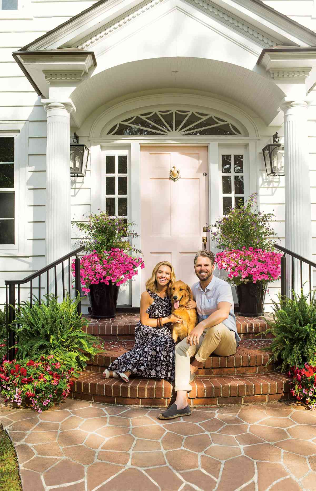 Lindsey and Grayson Cheek in front of their Wilmington, NC Home with a Pink Front Door