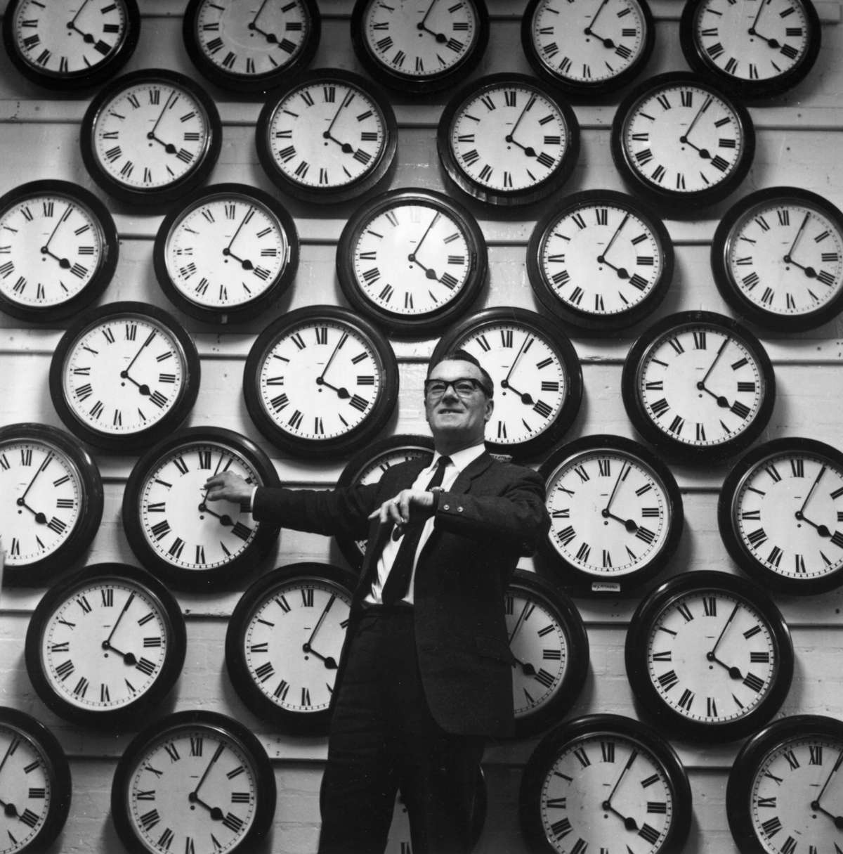 Man in Front of Wall of Clocks