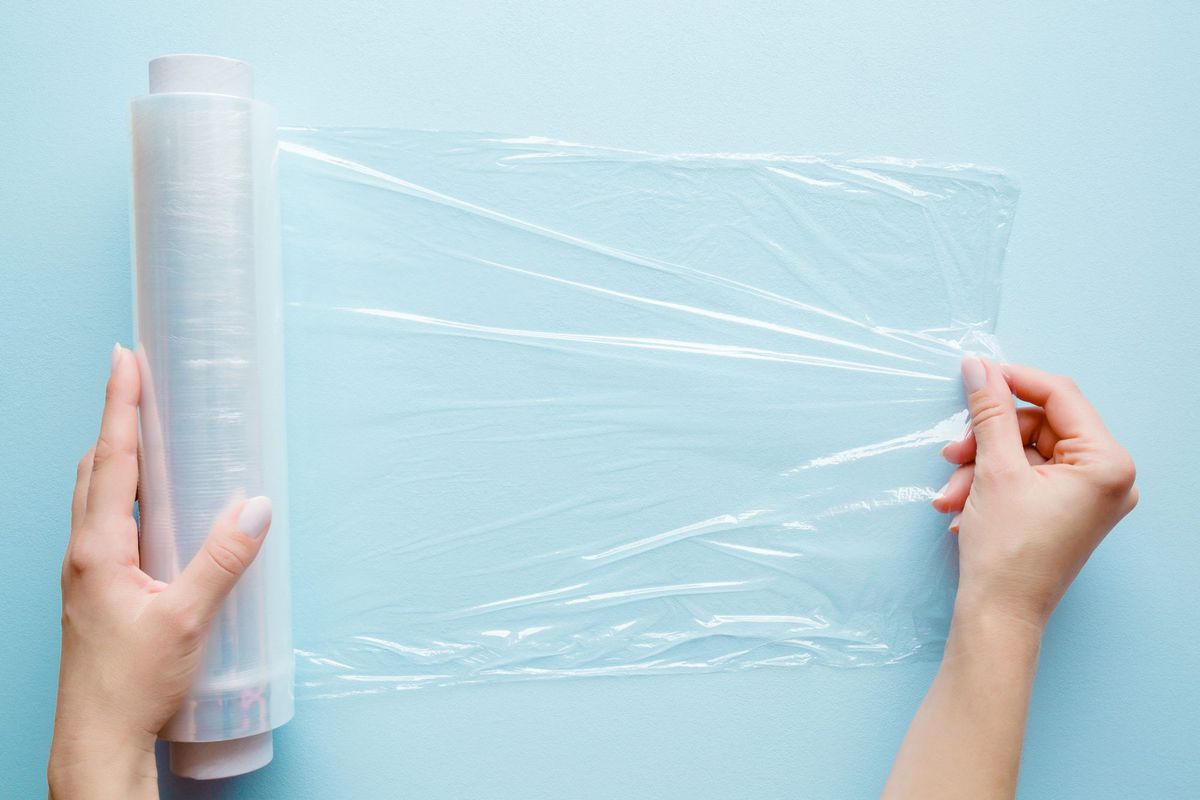 Woman Unrolling Plastic Wrap